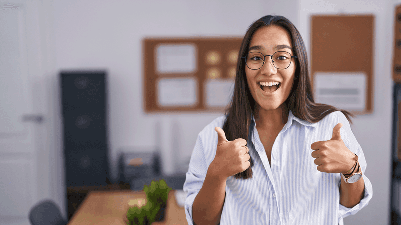 Kuvituskuvassa hymyilevä nainen pitää peukaloita ylhäällä.