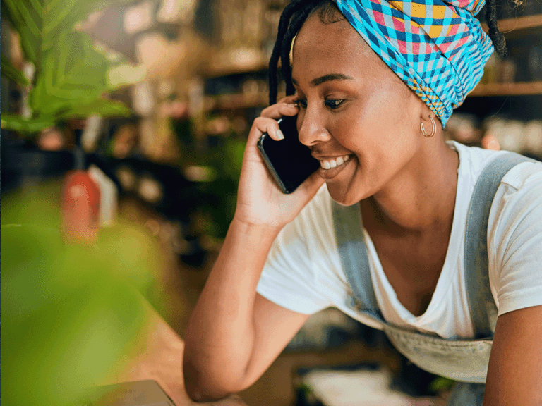 Kuvituskuvassa nuori työntekijä puhuu puhelimessa.