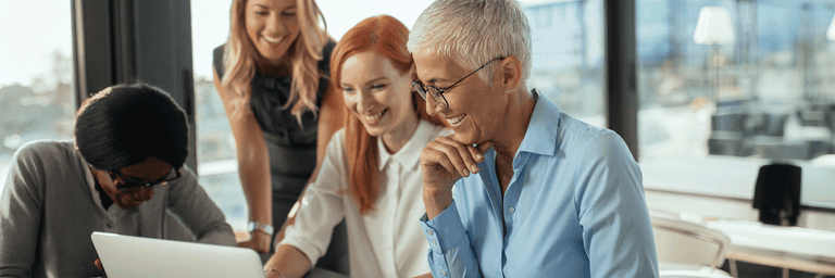 Hymyileviä eri-ikäisiä ihmisiä toimistoympäristössä